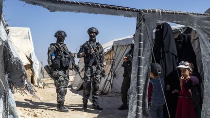 Des membres des forces de sécurité kurdes syriennes Asayish inspectent des tentes dans le camp d'al-Hol géré par les forces kurdes dans le nord-est de la Syrie, le 28 août 2022.&nbsp; (DELIL SOULEIMAN / AFP)