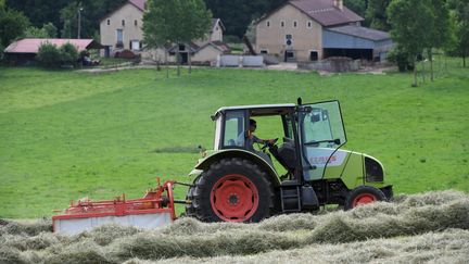 Un tracteur devant une ferme dans le Val d'Amour (Jura). Photo d'exposition. (JEAN PIERRE AMET / MAXPPP)