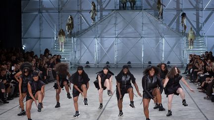 Rick Owens a organisé un anti-défilé. On se plaint souvent du manque de diversité chez les mannequins ou de leur maigreur. Le styliste américain a présenté sa collection sur des femmes bien portantes, en majorité noires, qui ont dansé sur des rythmes tribaux, le tout en grimaçant ou avec un air agressif. Les vêtements ? Du cuir, ce qui est fréquent chez Rick Owens. Beaucoup de noir, mais aussi du beige et du kaki très clair. A noter que se tient jusqu'au 29 novembre au Carpenters Workshop Gallery à Londres l’exposition "Prehistoric" du styliste. 
 (Miguel Medina / AFP)