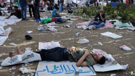 Samedi 9 juillet 2011, un jeune dort place Tahrir au Caire sur un Carton disant "le peuple veut renverser le régime". (AFP - Mohamed Hossam)