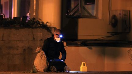 Un membre de la police scientifique inspecte les lieux apr&egrave;s l'explosion d'une bombe dans la nuit du 10 au 11 avril 2012, &agrave; Ajaccio (Corse-du-Sud). (PASCAL POCHARD-CASABIANCA / AFP)