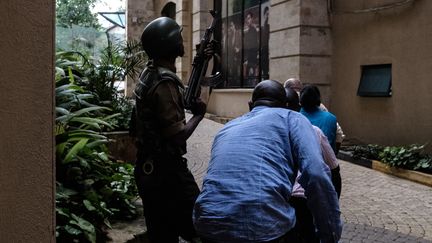 Un militaire évacue des civils après une attaque contre un complexe hôtelier à Naïrobi (Kenya), le 15 janvier 2019. (KABIR DHANJI / AFP)