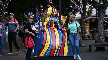 Des passantes posent à côté d'une Ménine exposée dans les rues de Caracas (Venezuela). (FEDERICO PARRA / AFP)