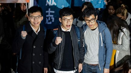 &nbsp;Joshua Wong (à gauche), Nathan Law (au milieu) et Alex Chow (à droite) leaders du mouvement des parapluies à Hong Kong en 2014. (ANTHONY WALLACE / AFP)