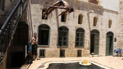 Des combattants de l'arm&eacute;e syrienne libre se relaxent dans une piscine &agrave; Alep (Syrie), le 24 juin 2013. (MUZAFFAR SALMAN / REUTERS)