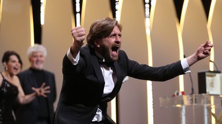 Le réalisateur suédois Ruben Östlund incite toute la salle à partager son immense joie d'avoir remporté la Palme d'or pour "The Square". 
 (Valéry Hache / AFP)