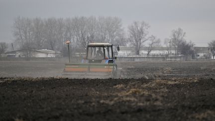 Un agriculteur sème des graines d'avoine dans un champ près de Kiev (Ukraine), en avril 2022. (GENYA SAVILOV / AFP)