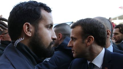 L'agent de sécurité Alexandre Benalla (à gauche) près d'Emmanuel Macron (à droite) lors de l'inauguration du Salon de l'Agriculture, le 24 février 2018, à Paris. (STEPHANE MAHE / POOL / AFP)