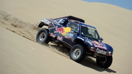 Carlos Sainz (Qatar Red Bull) descend une dune (FRANCK FIFE / AFP)