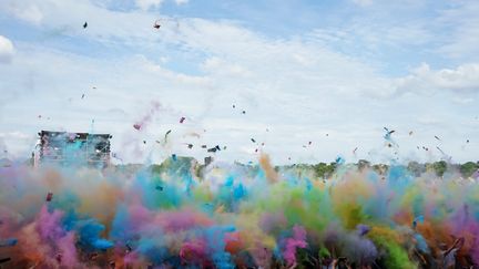 Des festivaliers lancent de la poudre colorée lors de la 21e édition des Solidays, le 23 juin 2019. (AFP)