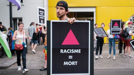 Une personne portant une affiche contre le racisme lors de "la marche des fiertés des banlieues", à Saint-Denis (Seine-Saint-Denis), le 4 juin 2022. (ANNA MARGUERITAT / HANS LUCAS)