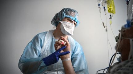 Une infirmière s'occupe d'un patient dans une unité Covid-19. (ANNE-CHRISTINE POUJOULAT / AFP)