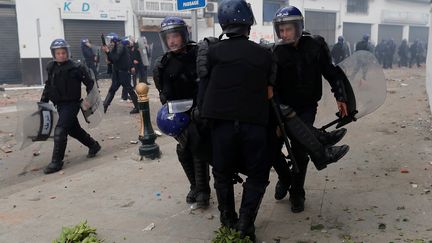 Un policier blessé est évacué par des collègues, le 8 mars 2019, en marge d'une manifestation d'opposants à Abdelaziz Bouteflika, à Alger (Algérie). (ZOHRA BENSEMRA / REUTERS)