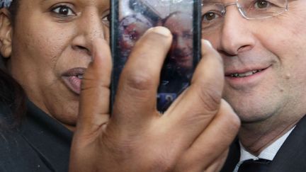 Une femme se prend en photo avec le pr&eacute;sident fran&ccedil;ais Fran&ccedil;ois Hollande lors de sa visite dans le quartier des&nbsp;Gr&eacute;silles, &agrave; Dijon&nbsp;(C&ocirc;te-d'Or), le 11 mars 2013. (PHILIPPE WOJAZER / REUTERS)