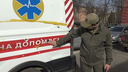 Maksim Khaoustov, chef de service de l'hôpital de Kharkiv (Ukraine), montre les impacts de tirs sur l'une des ambulances de la ville, le 4 avril 2022 (GILLES GALLINARO / RADIO FRANCE)