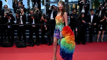 Sans aucun film en compétition, l'actrice&nbsp;Frédérique Bel n'a pas raté une montée des marches de la quinzaine, endossant à chacune une robe plus somptueuse que l'autre. Pour cette dernière soirée, elle s'est parée de ses plus belles couleurs. (PATRICIA DE MELO MOREIRA / AFP)