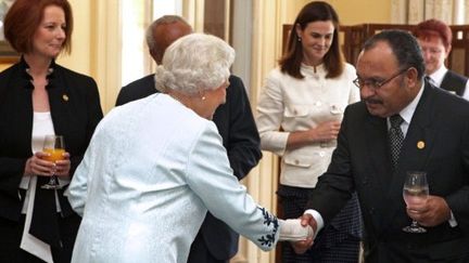 La reine d'Angleterre salue Peter O'Neill, président de Papouasie-Nouvelle-Guinée, avant le lancement de la réunion. (AFP PHOTO / POOL / COLIN MURTY)