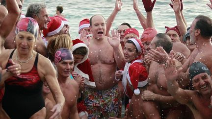 Le prince Albert II de Monaco prend la pose en compagnie des traditionnels nageurs de No&euml;l &agrave; Monaco, le 18 d&eacute;cembre 2011. (ERIC GAILLARD / REUTERS)