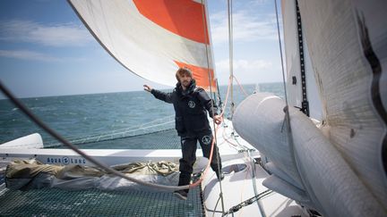 Romain Pilliard prêt à mettre les voiles pour son tour du monde à l'envers sur son&nbsp;trimaran "Use it again". (LOIC VENANCE / AFP)