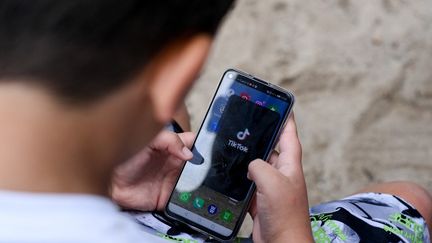 Un jeune adolescent utilise TikTok, à Berlin (Allemagne), le 5 août 2020.&nbsp; (JENS KALAENE / DPA-ZENTRALBILD / AFP)