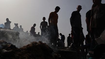 Des Palestiniens rassemblés autour de la zone frappée par l'armée israélienne, le 27 mai 2024. (EYAD BABA / AFP)