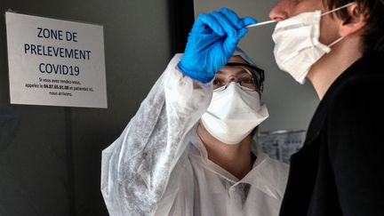 Un prélèvement réalisé au laboratoire CBM69 de Villeurbanne (Rhône), le 23 mars 2020. (JEFF PACHOUD / AFP)