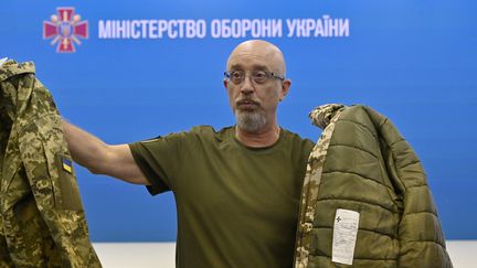 Le ministre ukrainien de la Défense, Oleksiy Reznikov, montre des uniformes militaires ukrainiens aux médias lors d'une conférence de presse à Kiev (Ukraine), le 28 août 2023. (SERGEI CHUZAVKOV / AFP)