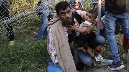 Des migrants tentent de franchir la fronti&egrave;re entre la Serbie et la Hongrie, pr&egrave;s de Horgos, le 14 septembre 2015, apr&egrave;s la mise en place de barbel&eacute;s par les autorit&eacute;s hongroises. (MARKO DJURICA / REUTERS)