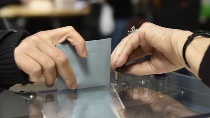 Un électeur&nbsp;glisse son bulletin de vote dans l'urne lors de la primaire de la gauche, le 29 janvier 2017 à Toulouse ( Haute-Garonne). (PASCAL PAVANI / AFP)