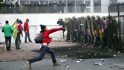 Un salari&eacute; de Goodyear fait face aux forces de l'ordre lors d'une manifestation devant le si&egrave;ge du fabricant de pneus &agrave; Rueil-Malmaison (Hauts-de-Seine), le 7 mars 2013. (LIONEL BONAVENTURE / AFP)