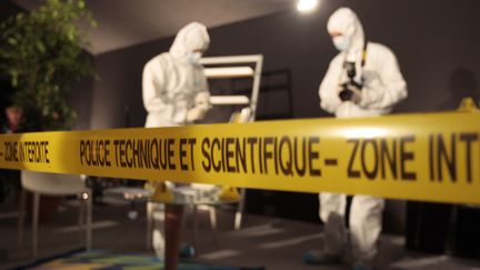 Des membres de la police technique et scientifique font une d&eacute;monstration de recherche d'indices sur une sc&egrave;ne de crime, le 17 octobre 2008 &agrave; Paris. (FRANÇOIS GUILLOT / AFP)