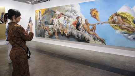 Une femme photographie une oeuvre à la foire Art Basel à Hong Kong en mars 2018 (KIN CHEUNG/AP/SIPA / AP)