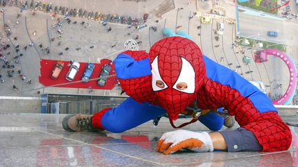 Un homme déguisé en Spider-Man grimpe la façade d'un building de 60 m de haut à Weifang, dans l'est de la Chine, en mai 2007. (CHINA DAILY / REUTERS)