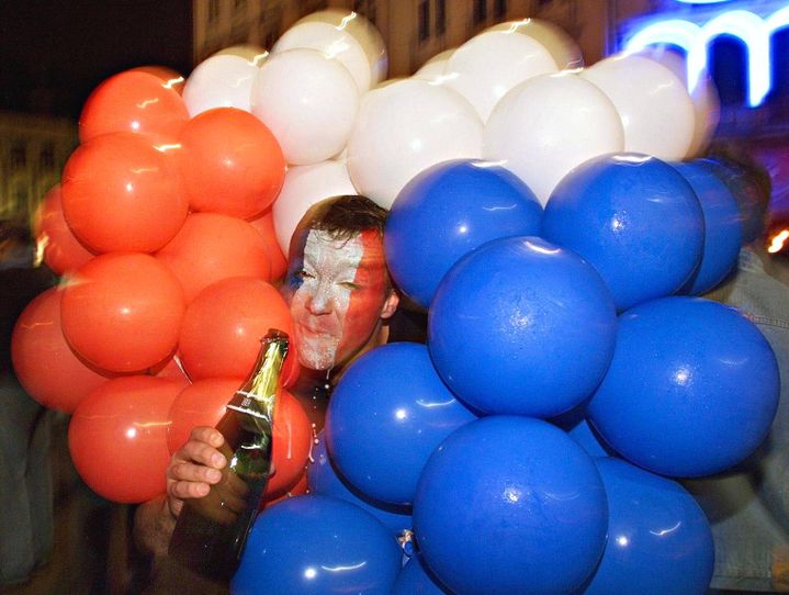 Un supporter de l'équipe de France fête la victoire des Bleus en Coupe du monde, le 12 juillet 1998, dans les rues de Lille (Nord). (PHILIPPE HUGUEN / AFP)