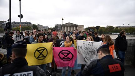 Des militants du mouvement écologiste Extinction Rebellion bloquent un pont menant à l'Assemblée nationale, à Paris, le 12 octobre 2019. (MARTIN BUREAU / AFP)