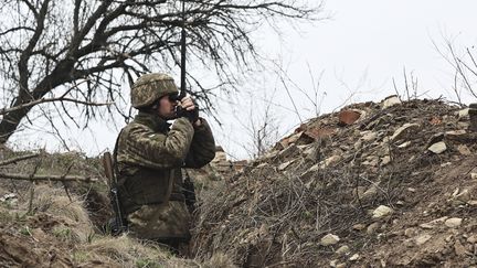 Un soldat ukrainien observe la ligne de front avec les séparatistes prorusses près de Donetsk, en Ukraine, le 12 avril 2021. (AP)