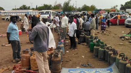 Sudanese people wait for the arrival of a gas truck to exchange their empty canisters, in Wad Madani, Sudan, on June 14, 2023. (AFP)