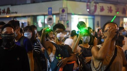 Des manifestants utilisent des pointeurs laser à Hong Kong, le 14 août 2019. (MANAN VATSYAYANA / AFP)