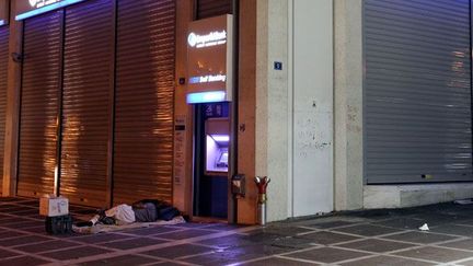 devant un bureau de banque au centre d'Athènes, le 21 août 2011. 

En deux ans, le nombre de SDF a augmenté de 25%. Près de 25 000 personnes vivent dans la rue. La grande majorité est immigrée. Une cinquantaine de camps de sans-abris se sont édifiés autour de la capitale. (REUTERS/Yiorgos Karahalis )