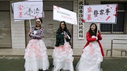 Des &eacute;tudiantes chinoises manifestent contre les violences domestiques, le 25 novembre, dans la province de Hubei. "Les violences conjugales sont ill&eacute;gales", "dois-je rester silencieuses ?" disent leurs pancartes. (DARLEY SHEN / REUTERS )