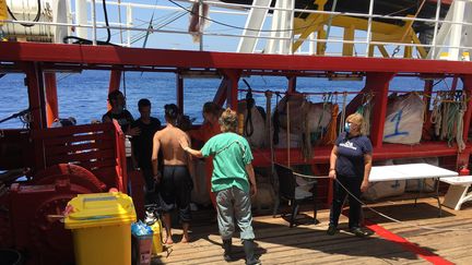 Des bénévoles de SOS Méditerranée viennent en aide à un groupe de migrants secourus en mer, à bord de l'Océan Viking, le 2 juillet 2020. (SHAHZAD ABDUL / AFP)