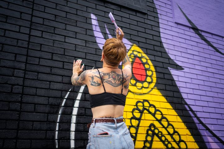 Nikki, une assistante de l'artiste Hatecopy, peint sur un mur pendant le festival Mural à Montréal, au Québec, le 16 juin 2022. (PAOLA CHAPDELAINE / AFP)