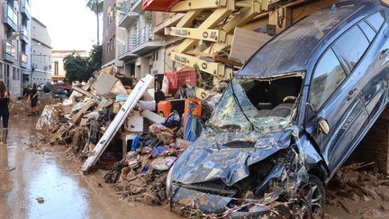 La présence de boue et de véhicules accidentés ralentit la progression des secours dans l'une des localités les plus touchées par les inondations en Espagne. (FABIEN COTTEREAU / MAXPPP)