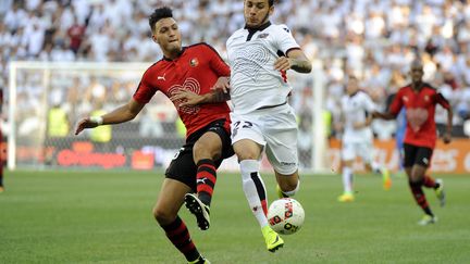 Anastasios Donis à la lutte avec le défenseur de Rennes Ramy Bensebaini (FRANCK PENNANT / AFP)