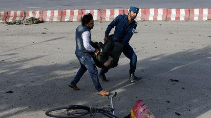 Des membres des forces de sécurité, portent un blessé, après un attentat-suicide, à Kaboul (Afghanistan), le 22 juillet 2018. (OMAR SOBHANI / REUTERS)