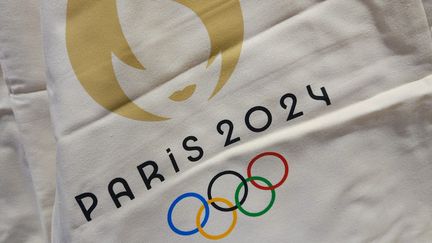 Le logo officiel des Jeux olympiques de Paris 2024, imprimé sur du textile, le 14 août 2023. (ARTUR WIDAK / NURPHOTO / AFP)