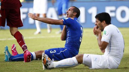 L'italien Giorgio Chiellini se plaint d'une morsure pendant que l'Uruguayen Luis Suarez se tient les dents, le 24 juin &agrave; Natal. Le geste fait le tour du monde et&nbsp;l'attaquant est suspendu quatre mois des terrains. (TONY GENTILE / REUTERS)