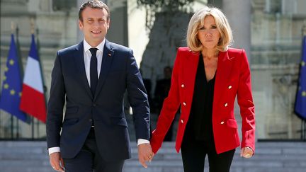 Emmanuel et Brigitte Macron, dans la cour de l'Elysée, à Paris, le 6 juillet 2017. (THIBAULT CAMUS / REUTERS)