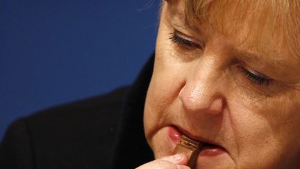 La chanceli&egrave;re allemande Angela Merkel croque dans du chocolat pendant une convention de son parti le CDU &agrave; Leipzig (Allemagne), le 14 novembre 2011. (KAI PFAFFENBACH / REUTERS)