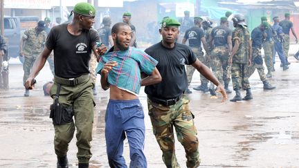 Dans cette photo d'archive prise le 28 septembre 2009, la police guinéenne arrête un manifestant devant le plus grand stade de la capitale Conakry lors d'une manifestation interdite par la junte au pouvoir en Guinée.  (SEYLLOU / AFP)